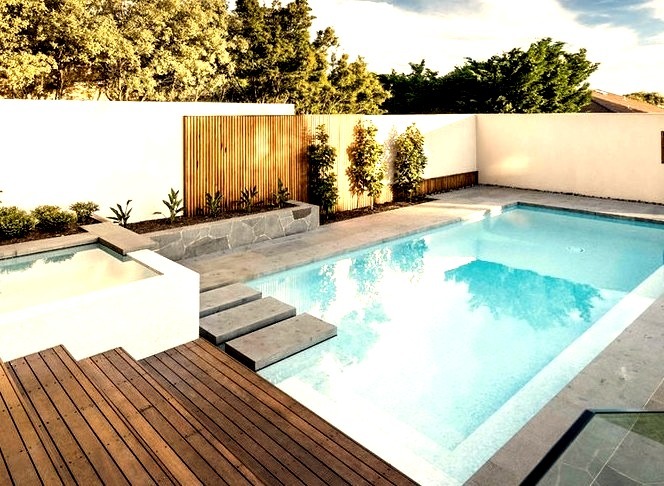 A large, modern backyard image with a rectangular infinity hot tub